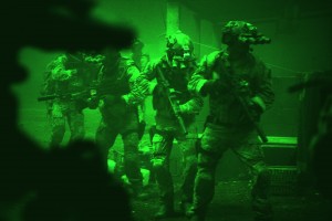 Seen through the greenish glow of night vision goggles, Navy SEALs prepare to breach a locked door in Osama Bin Laden's compound in Columbia Pictures' hyper-realistic new action thriller from director Kathryn Bigelow, ZERO DARK THIRTY. ©Columbia Pictures. CR: Jonathan Olley.