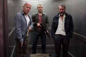 (l-r) John McClane (Bruce Willis), Jack McClane (Jai Courtney) and a Russian under their protection, Komarov (Sebastian Koch), take a fateful elevator ride in "A GOOD DAY TO DIE HARD." ©Frank Masi/20th Century Fox.