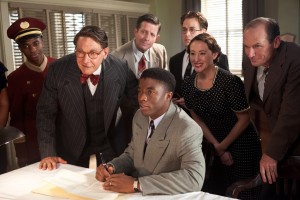 (Center l-r) HARRISON FORD as Branch Rickey and CHADWICK BOSEMAN as Jackie Robinson, T.R. KNIGHT (standing) as Harold Parrott, RHODA GRIFFIS as Miss Bishop and TOBY HUSS as Clyde Sukeforth in "42." ©Warner Bros. Entertainment/Legendary Pictures. CR: D. Stevens.
