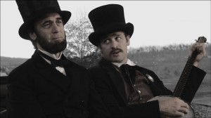 Ward Hill Lamon (Lea Coco, right) tries to cheer his melancholy friend, President Lincoln (Tom Amandes) with a song in "Saving LIncoln." ©Saving Lincoln, LLC.