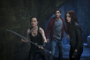 (l-r) Isabelle Lightwood (Jemima West), Simon (Robert Sheehan) and Clary (Lily Collins) prepare to hold off the demons in Screen Gems THE MORTAL INSTRUMENTS: CITY OF BONES. ©Constantin Film International GmbH and Unique Features (TMI) Inc. CR: Rafy.