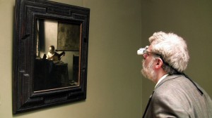 Tim Jenison, wearing his surgical loupes, inspects Johannes Vermeer’s “Woman with a Lute” at the Metropolitan Museum of Art in New York in the film TIM'S VERMEER. ©High Delft Pictures. CR: Shane F. Kelly.
