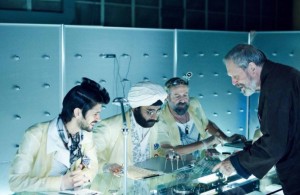 Terry Gilliam (standing) gives instructions to actors on the set of ZERO THEOREM. ©Voltage Pictures.