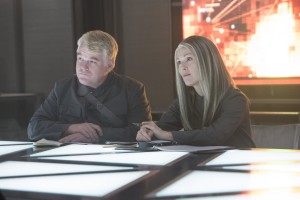 Plutarch Heavensbee (Philip Seymour Hoffman) and President Coin (Julianne Moore) in THE HUNGER GAMES: MOCKINGJAY – PART 1. ©Lionsgate Entertainment. CR: Murray Close.