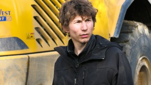 Parker Schnabel in front of a construction vehicle in GOLD RUSH. ©Discovery Channel.