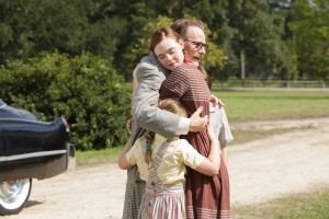 Dalton Trumbo (right, Bryan Cranston) comes home to the embrace of his children, including daughter Niki Tumbo (left, Elle Fanning) in Jay Roach’s TRUMBO. ©Bleecker Street. CR: Hilary Bronwyn Gail/Bleecker Street.
